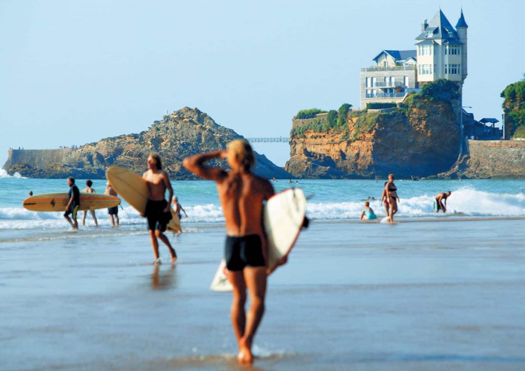 Surfistas en la Côte des Basques frente a los acantilados de Biarritz